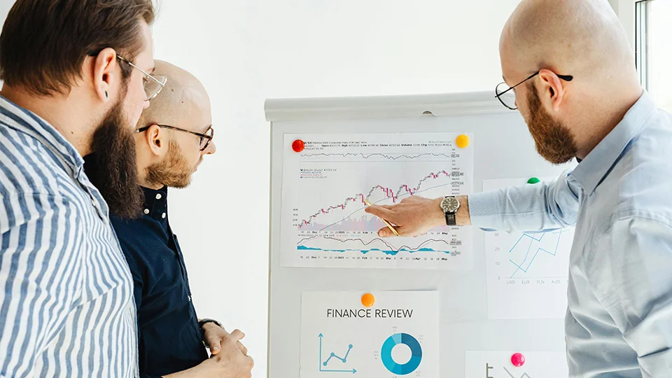 Business associates looking over a finance review on a board