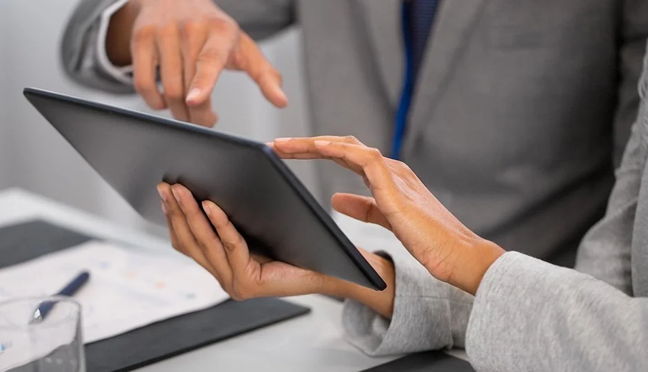 business associates reviewing items on a tablet screen