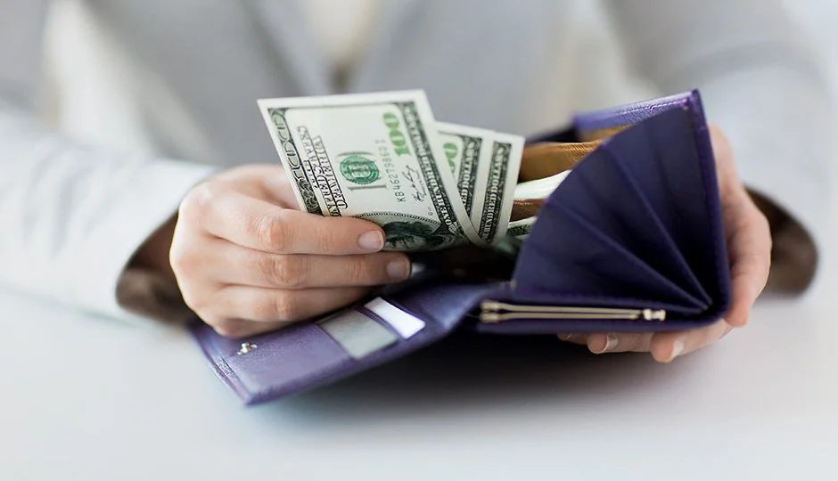 hand taking money of of a blue wallet
